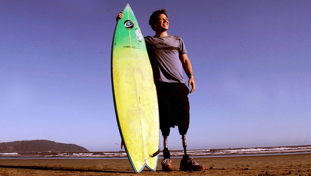 Pauê Chieffi Aagaard segundado a prancha de surfe na praia de santos