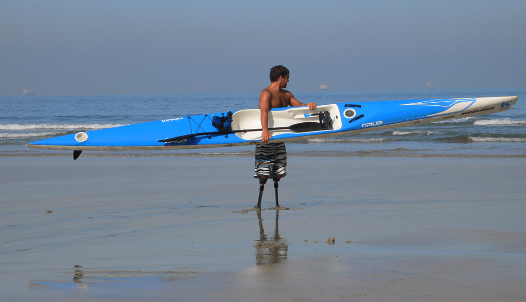 Pauê Chieffi Aagaard segurando um surfski na praia de Santos