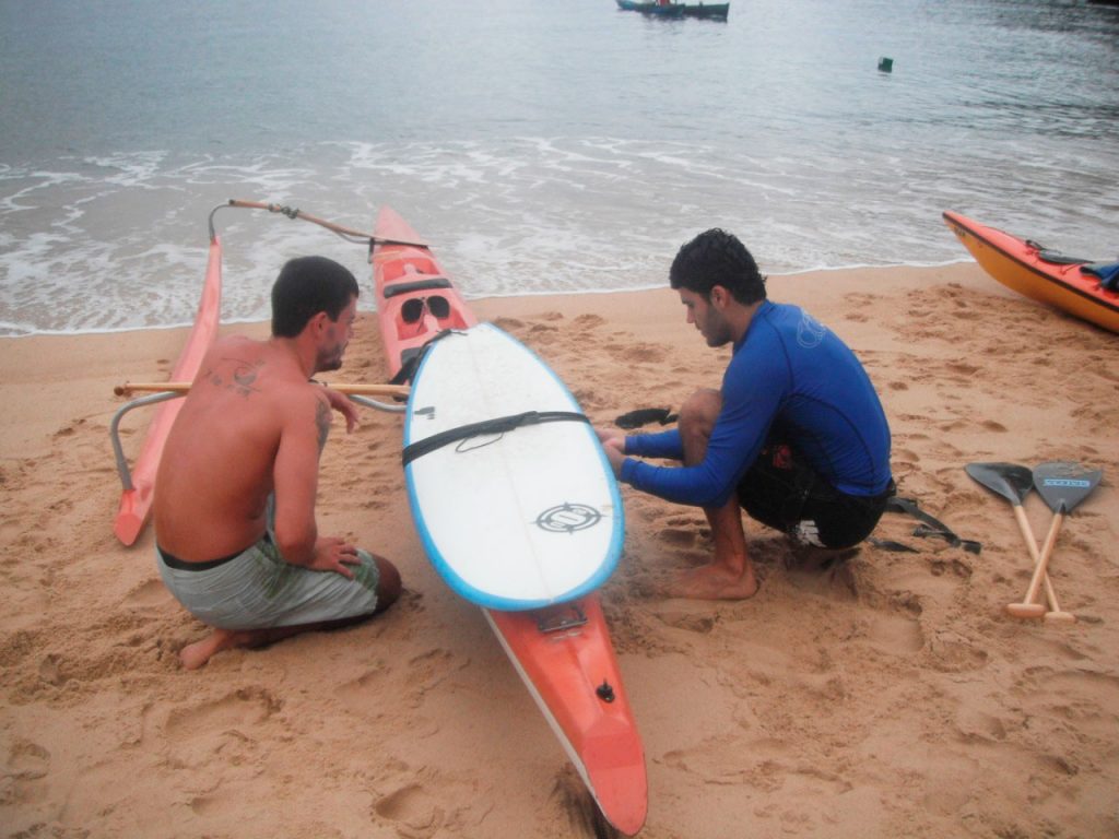 Os amigos Douglas e Eduardo fazendo os ajustas na amarração da prancha na canoa.