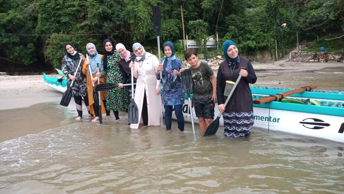Grupo de mulheres libanesas remando de canoa havaiana em Santos