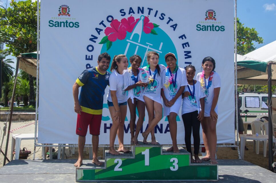 Jefferson Libório ao lado de sua filha, Bruna (à esq.) ao lado da algumas das crianças atendidas por seu projeto durante competição de canoagem em Santos (SP). 